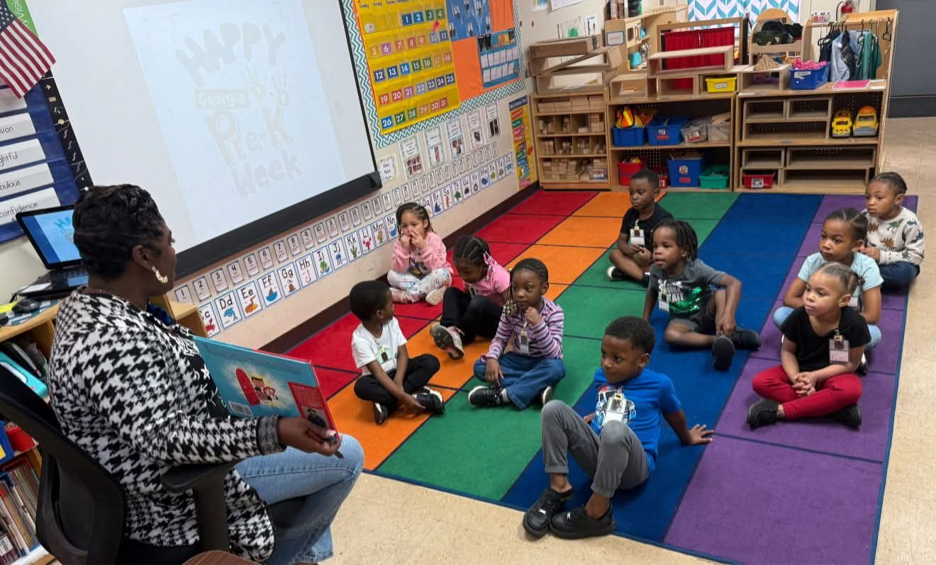 Teacher reading to a group of children in a bright classroom